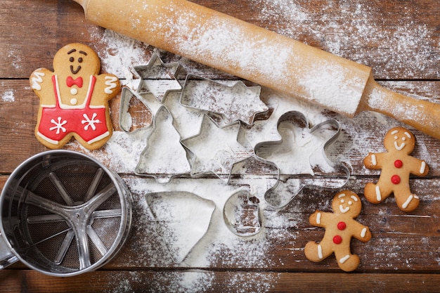 Christmas baking. Gingerbread cookies and kitchen utensils on wooden table, top view