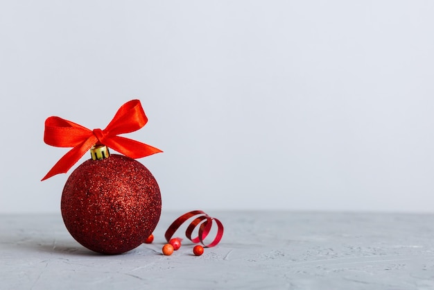 Christmas ball on colored background decoration bauble with ribbon bow with copy space