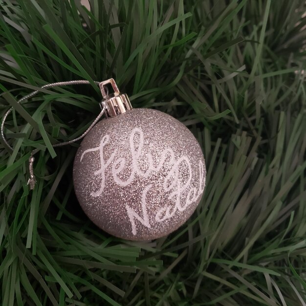 Photo christmas ball decorated with words. merry christmas. feliz natal.