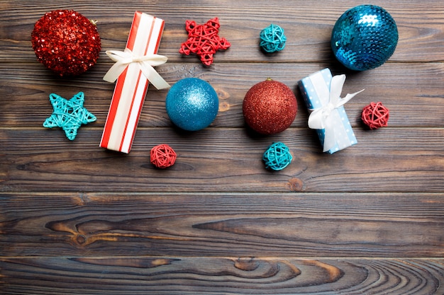 Christmas ball, gift and creative decorations on wooden background