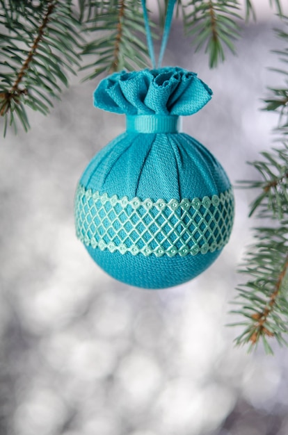 Christmas ball hanging on fir branch on silver background New year decoration