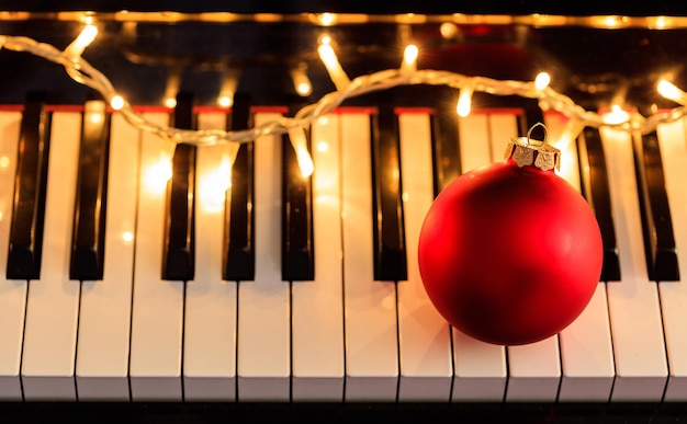 Christmas ball and lights on a piano keyboard above view