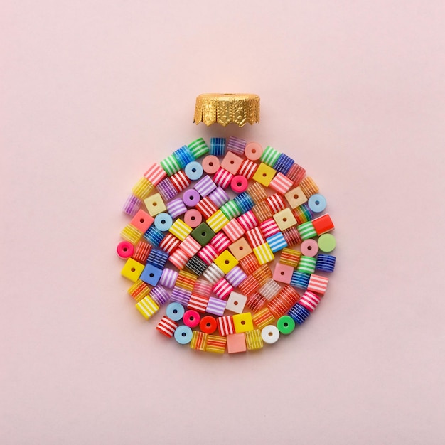 Christmas ball made of decoration elements on pink background Flat lay