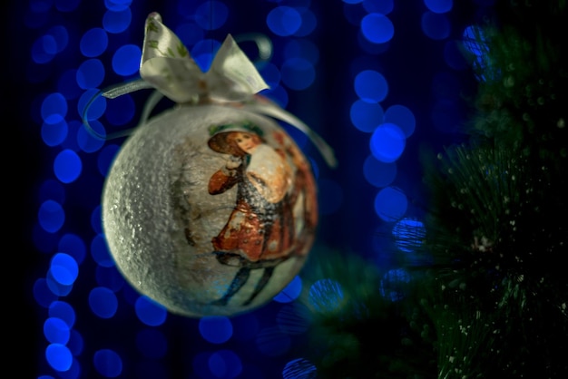 Photo christmas ball near christmas tree on neon blue background