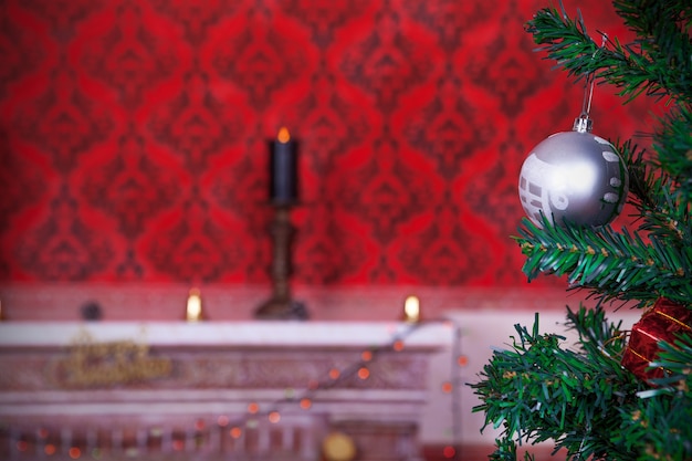 Palla di natale su uno sfondo rosso vintage con una candela accesa