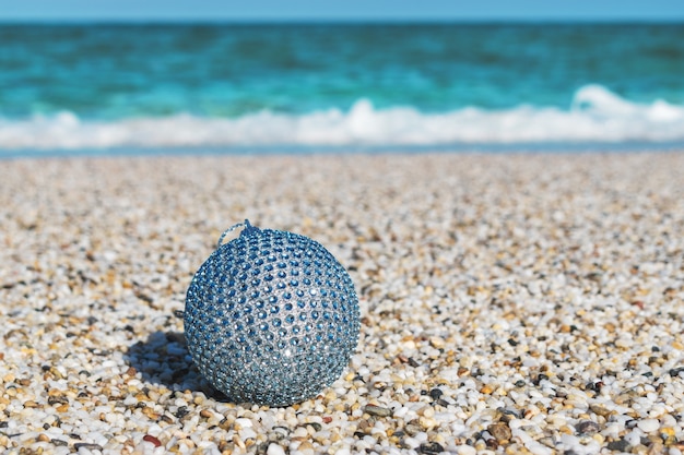 Christmas ball on the sand on a tropical beach