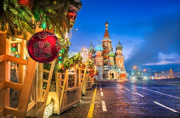 Christmas ball on spruce branches of trading houses on Red Square in Moscow and St. Basil's Cathedral on a winter morning