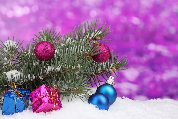 Christmas ball and toy with green tree in the snow on purple