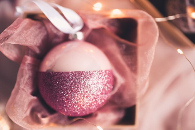 Christmas ball with glitter in open box closeup. Winter holidays. Celebration.