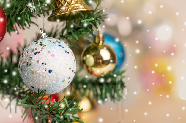 Christmas balls and bell hanging on the branch of the pine