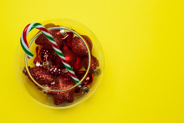 Christmas balls and candy cane in a round vase, top view