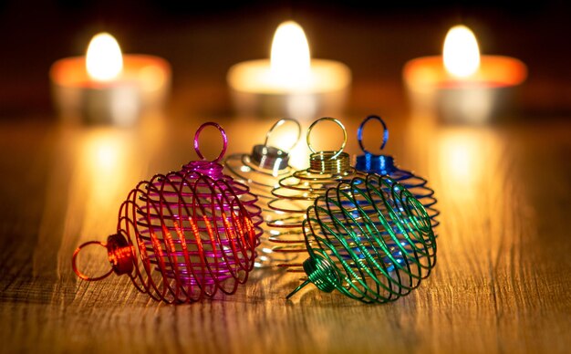 Christmas balls of colored metal wire and lighted candles