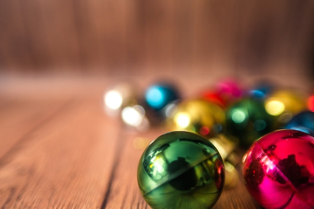 Christmas balls of different colors lie on a wooden