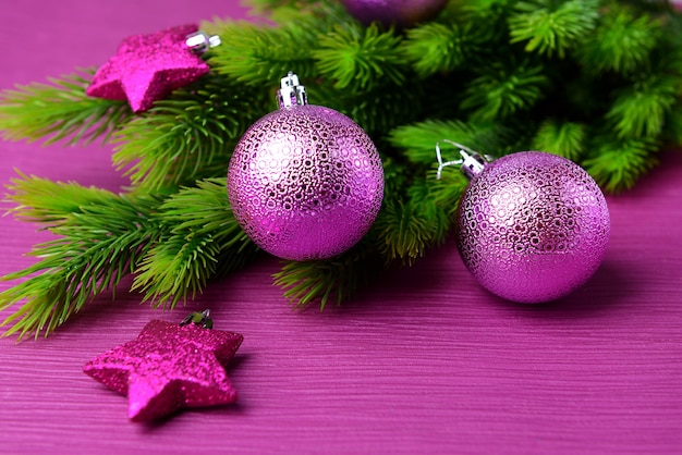 Christmas balls on fir tree, on color background