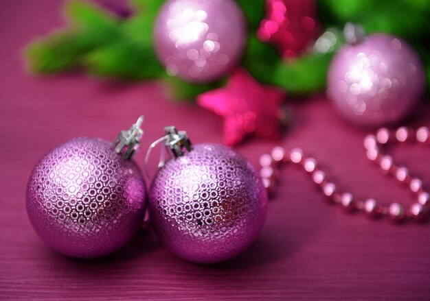 Christmas balls on fir tree, on color surface