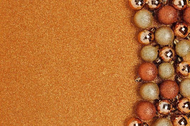 Cornice di palle di natale su sfondo oro scintillante