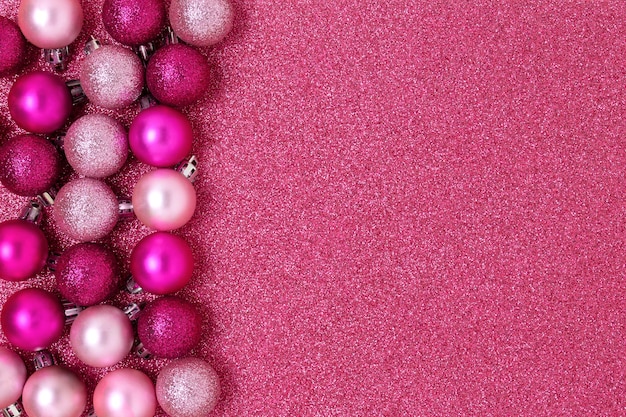 Christmas balls frame on a pink glittering background