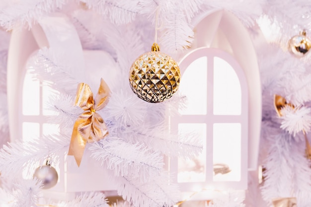 Christmas balls and garlands in the form of windows on a white Christmas tree