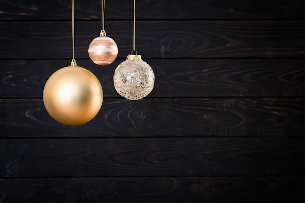 christmas balls hanging on dark wooden background