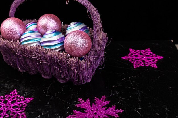 Christmas balls in purple basket. Decorative snowflakes.