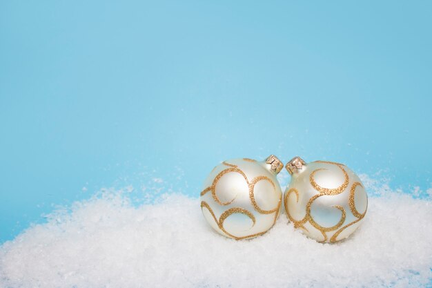 Christmas balls in the snow on a gentle blue wall