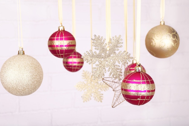 Christmas balls and snowflakes hanging on light blurred background