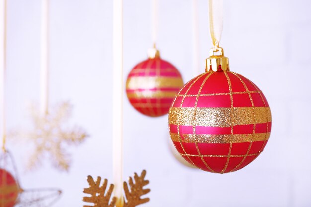 Christmas balls and snowflakes hanging on light blurred background