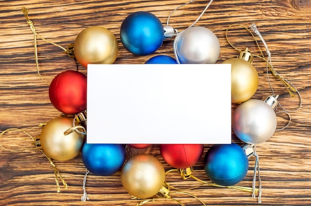 Christmas balls with blank business card on the table New year background Top view