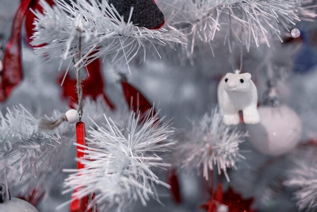 Photo christmas balls with red ribbons at white christmas tree with best wishes