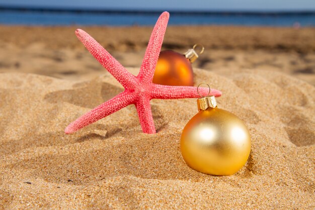 Christmas balls with starfush on beach