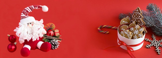 Christmas banner Christmas toy Santa Claus and gift box with gingerbread on the red background Copy space