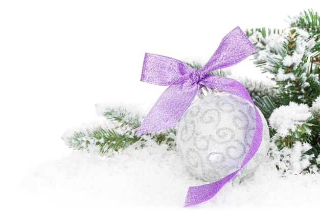 Christmas bauble and purple ribbon with snow fir tree