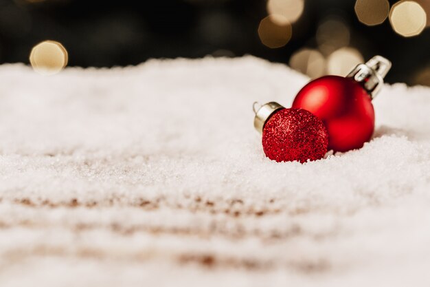 雪に覆われた木製のテーブルにクリスマス安物の宝石。クリスマスのコンセプト