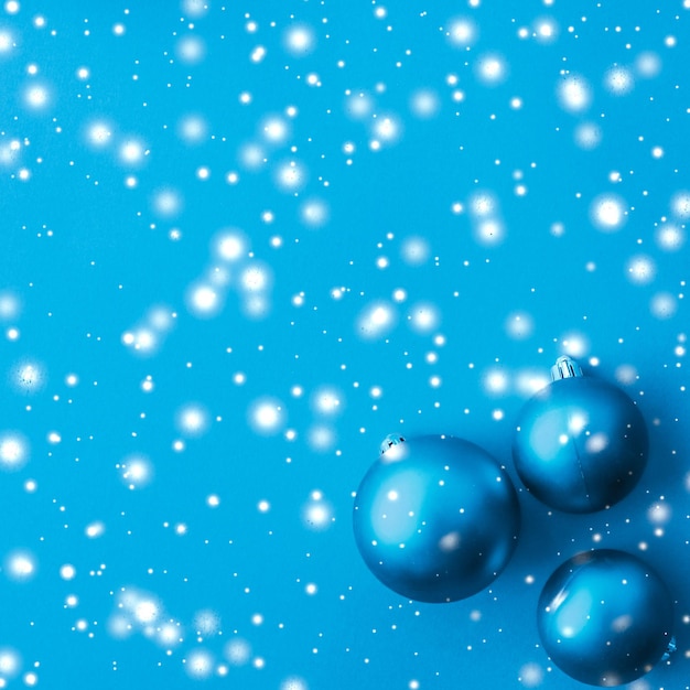 Christmas baubles on blue background with snow glitter luxury winter holiday card