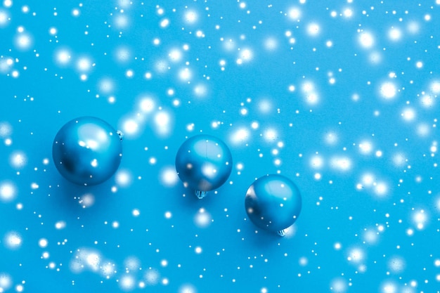 Christmas baubles on blue background with snow glitter luxury winter holiday card