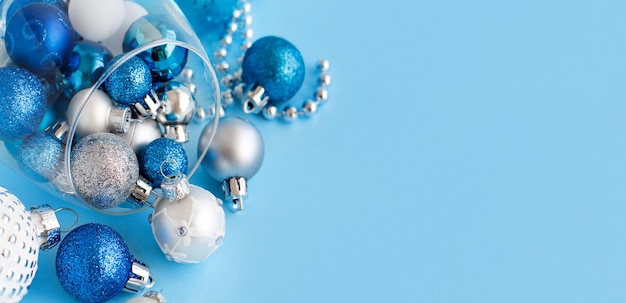 Рождественские шары в бокале на голубом фоне