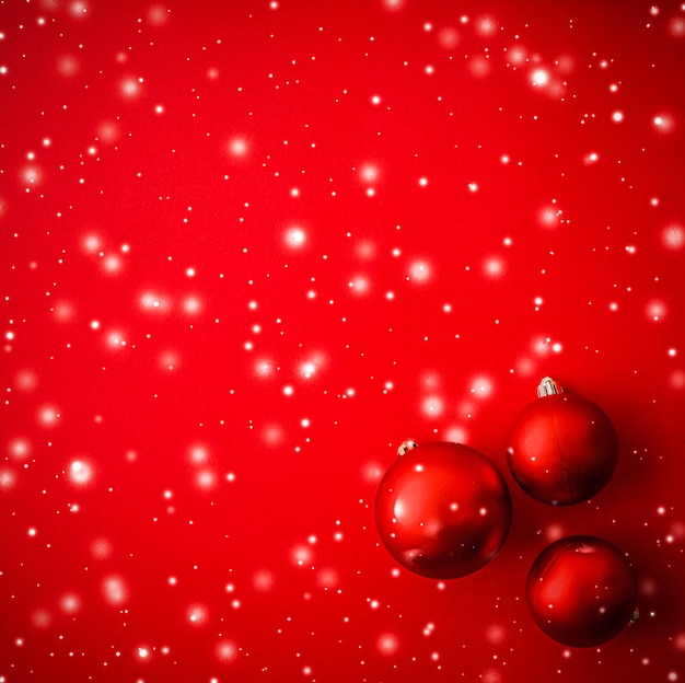 Фото Рождественские безделушки на красном фоне со снежным блеском роскошная зимняя праздничная открытка