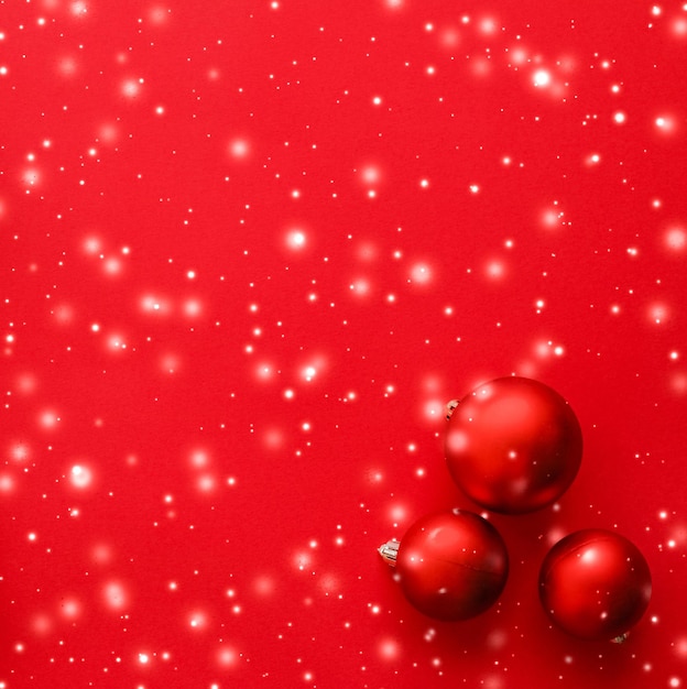 Christmas baubles on red background with snow glitter luxury winter holiday card