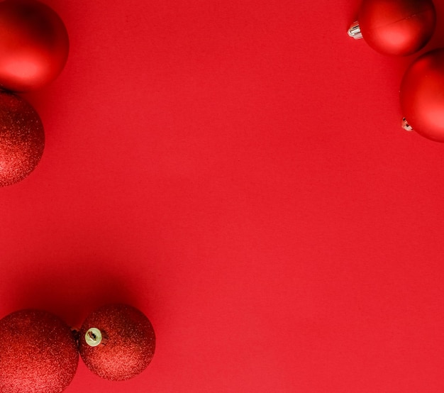 Foto palline di natale su sfondo rosso flatlay carta di vacanza invernale di lusso sfondo