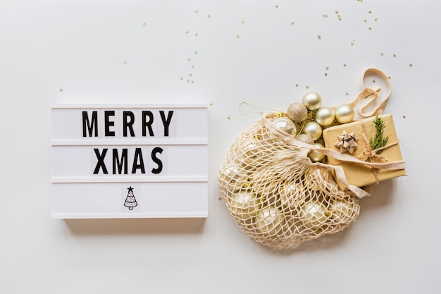 christmas baubles in string bag on white