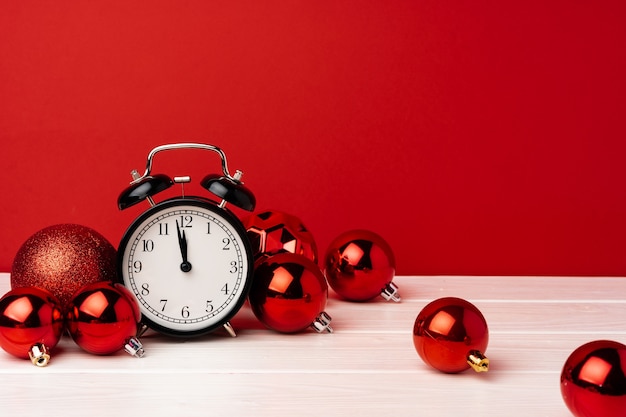 Christmas baubles with alarm clock on red