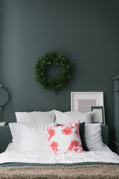 Christmas bedroom interior with a bed and a wreath above it in blue and white tones