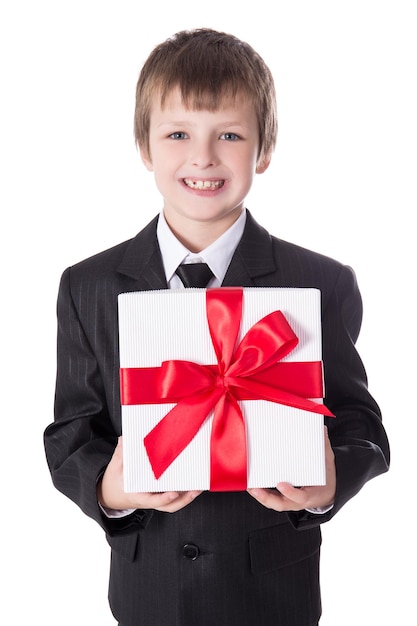 Christmas or birthday concept - little boy in business suit with gift box isolated on white background