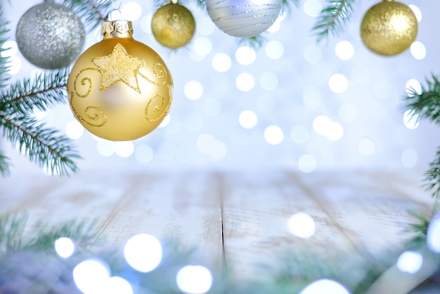 Christmas bokeh background with fir branches, gold and silver ornate ball.