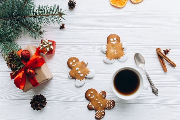 Christmas border. Gingerbread cookies, spices and decorations on white wooden background.