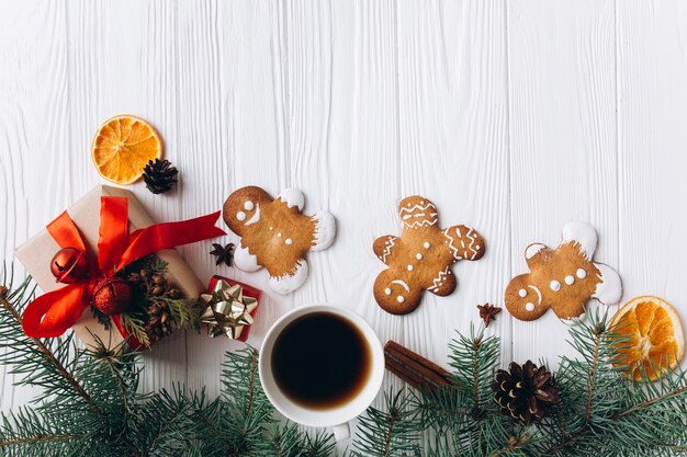 Christmas border. Gingerbread cookies, spices and decorations on white wooden background.