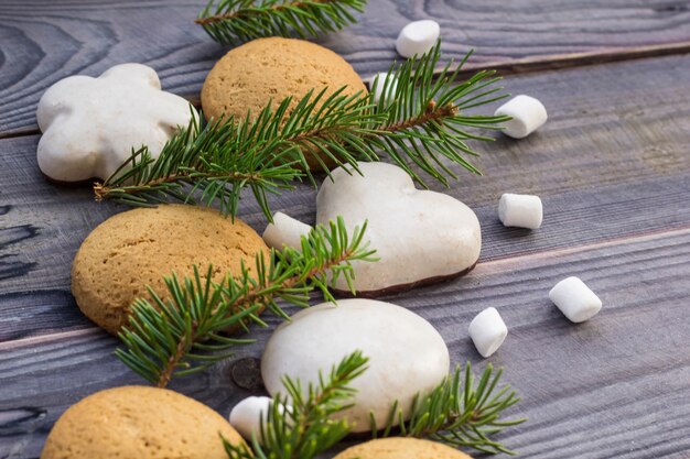 Christmas border with gingerbread, marshmallow and branch of fir tree.