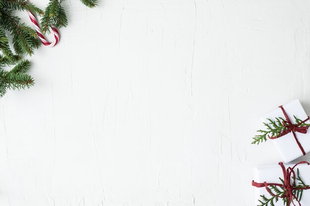 Photo christmas boxes and twigs on grey background