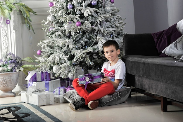 Christmas boy around Christmas tree with gifts