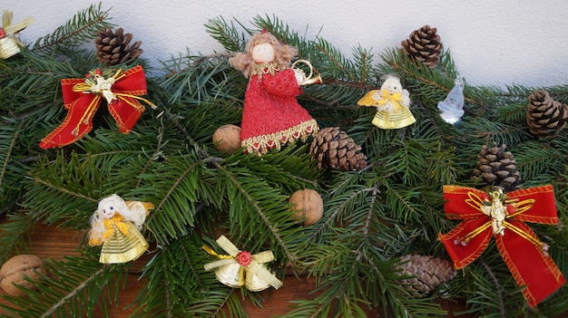 Christmas branches on wood with bell, bow and pine cones